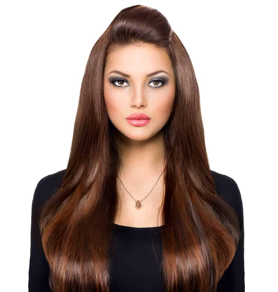 This is a classic example of a straight brunette hairstyle with healthy locks of hair flowing down on both sides and a poof in the front. This kind of style gives the hair great volume and structure. 