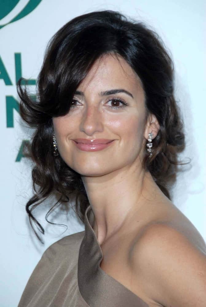 Check out this amazing look sported by the ever-lovely, Penelope Cruz. The hairstyle features long brunette hair tied in a loose, messy side bun. Coupled with side bangs, this fair style gives you the perfect opportunity to show off your earrings. If you are looking for a contemporary hairstyle that portrays class, elegance, and distinctive beauty, all in one— this is the hairstyle for you!