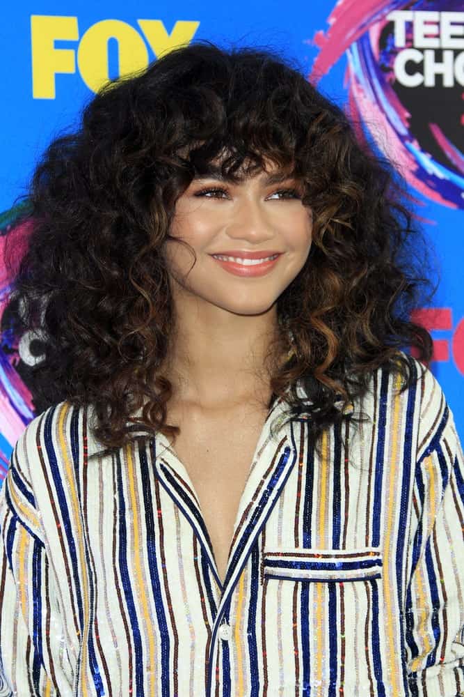 Zendaya knows how to rock her hair, be it natural or in a sleek style. The actress and singer kept her hair in tight, tousled curls but gave the locks framing her face a fiery color, for a super-dramatic effect.