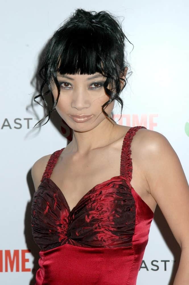 This is not your ordinary blunt bangs and hair down kind of hairstyle. Modeled by Bai Ling, it features straight-cut blunt bangs covering the forehead. A few locks of tight curly hair hang loosely around on both sides of the face; help frame it to bring focus to the eyes. Finally, the rest of the hair is tied in a bun at the back. End result – a perfect look! 