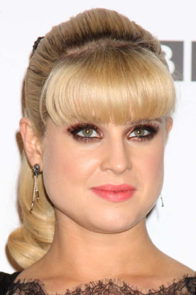 For the perfect evening look, recreate this hairstyle modeled by Kelly Osbourne. While blunt bangs are clearly the hero when it comes to this hairstyle, the rest of the hair is tied in a ponytail. Take notice of the volume of the hair. This makes sure that your hair does not look bland or too flat. To add the final touch, slightly curl the end of the ponytail. 