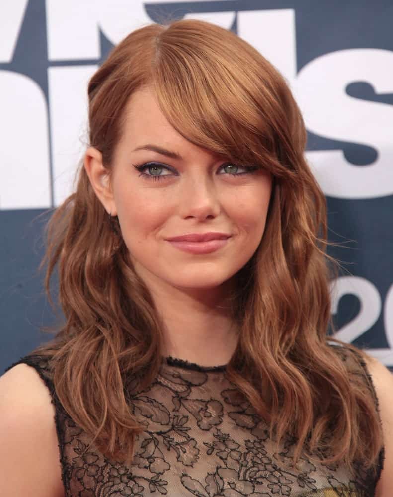 Emma Stone has been an advocate of side-swept bangs for a very long time. Take a look at how she looks stunning on the red carpet with her thick side bangs and the oh-so-amazing hazelnut hair color. 