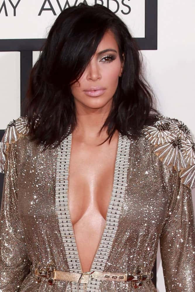 The heavy, thick side bang swept to the side pair perfectly with the messy bob framing Kim Kardashian’s face. The untidiness of the hair adds to the volume and will attract attention to your cheekbones and jaw line.