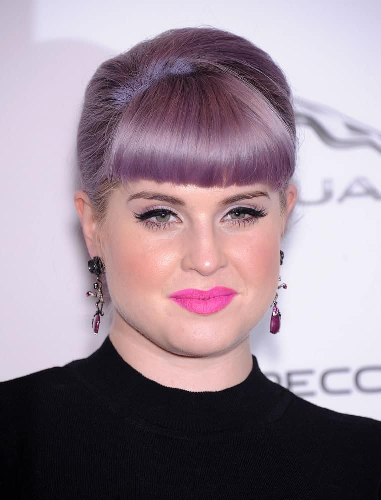 Looking for a “neat” look? Check out this hairstyle! Sported by Kelly Osbourne, this hairstyle features classic blunt bangs with hair neatly tied in a bun at the back. A hairstyle as elegant as this one is hard to miss. Go with this style when you want to showcase your earrings. To tweak things up, just like Kelly, you can experiment with hair color as well! 