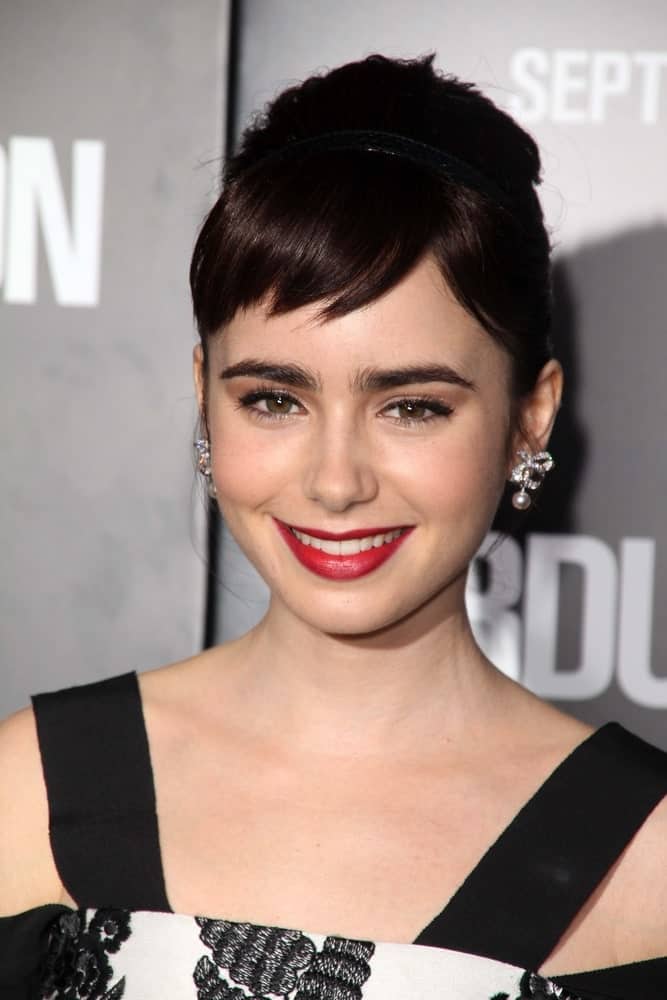 Lily Collins uses short, straight bangs to highlight her cheekbones and gorgeous clear skin in the most perfect way possible. The rest of her hair is in an elegant bun, which emphasizes her long neck and collarbones. The whole hairstyle is a great example of how amazing short bangs can look.