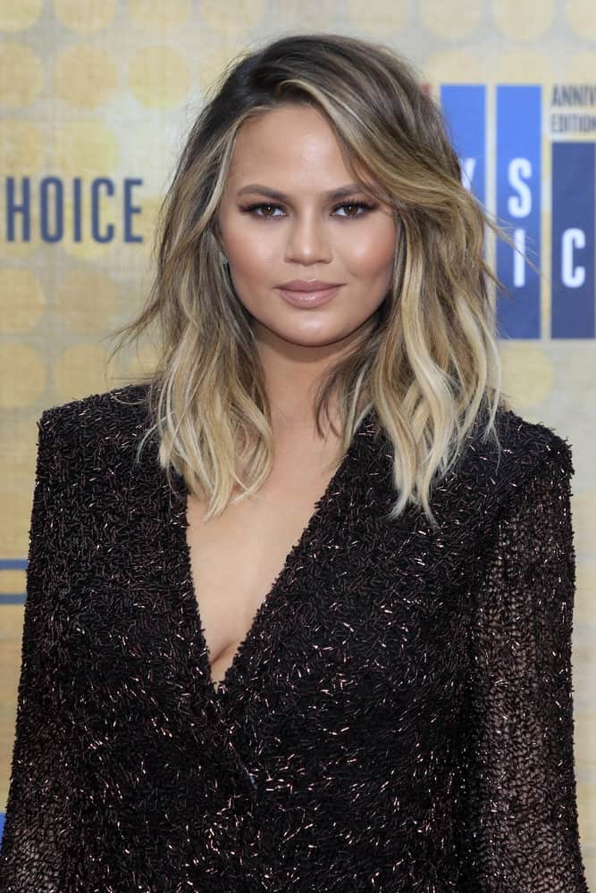 The side bangs are swept to one side, so that the hair looks like it is flowing in the wind. The messy waves in the hair paired with the blond tones look elegant. 