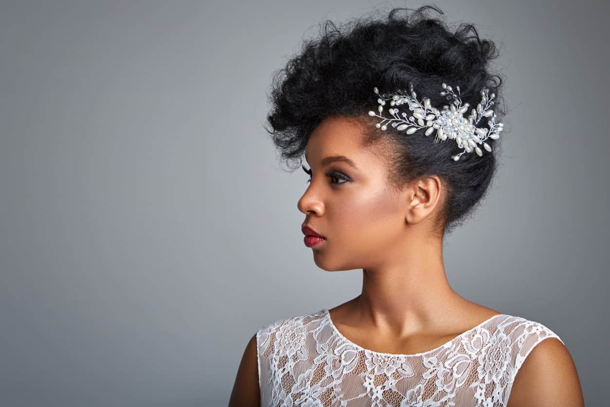 Tight coils can be piled on the top while the sides are framed with pretty flowers. This is the perfect look for a bride or for a formal event. 