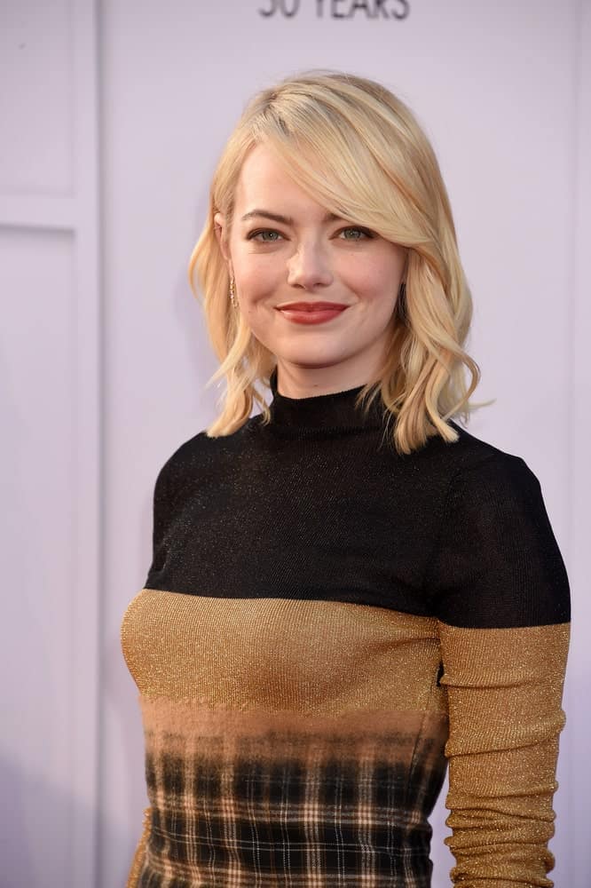 Emma Stone manages to look exceptionally effortless with the straight long side bangs ending in the perfect curl against her blond hair. 
