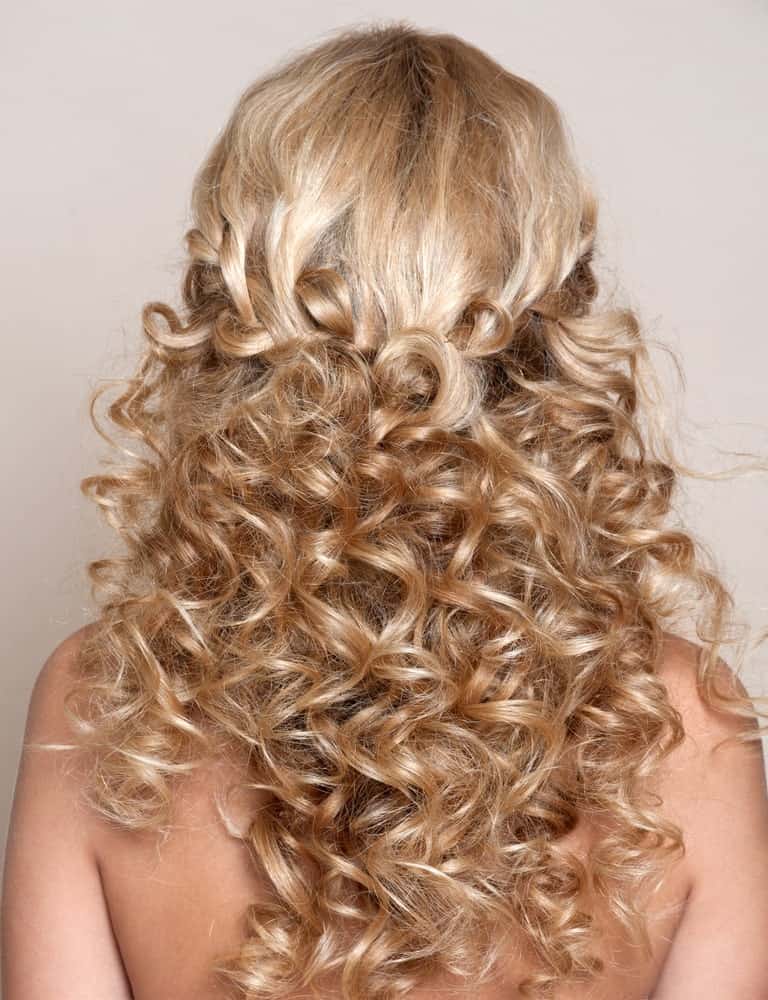 Nothing can beat this hairstyle in cuteness because it’s just so adorable. Plus, it is perfect for all occasions – from weddings to a beach day, this hairstyle offers just the right look. It features long curly blonde hair that is set in a loose and messy, stylish braid at the back of the head. Below the braid, the curls hang down the shoulder, reaching to the back. This hairstyle offers the perfect opportunity to showcase your majestic curls without overdoing it. In the front, it perfectly frames your face while making sure yours stay out of your face. Keep in mind that contrary to how it looks, the hairstyle is relatively easy to create and with a little practice, you can master it in no time! 