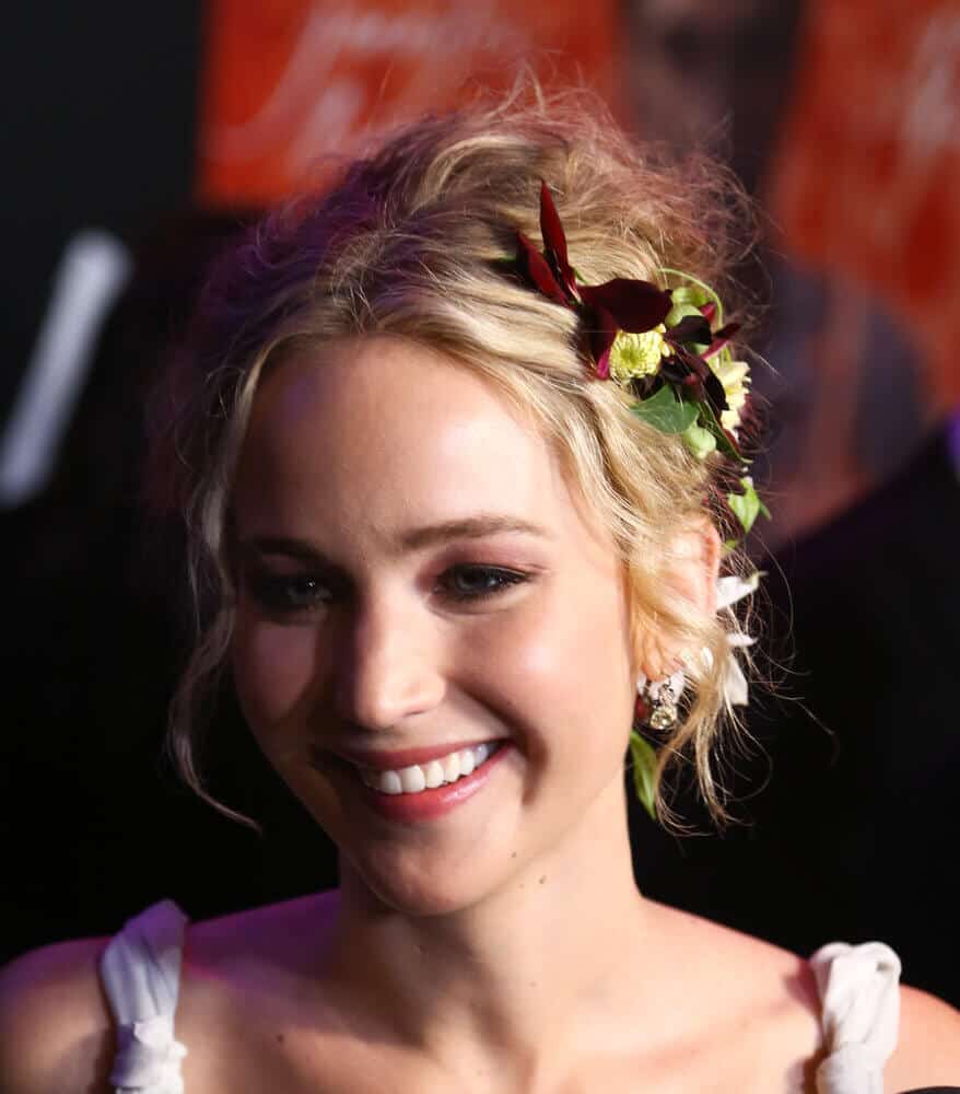 Jennifer Lawrence screams flower power as she wears her upstyle with colorful, floral embellishments.