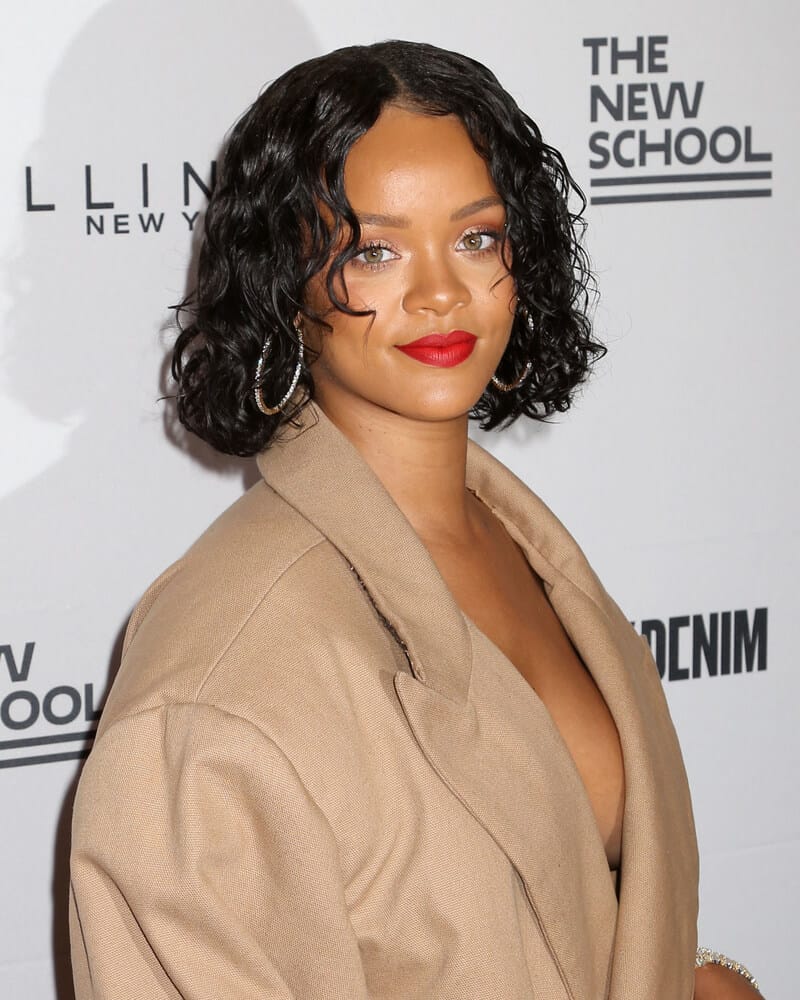 Rihanna sporting a carefree look with her curly bob, styled with hair mousse for a maintained finish.
