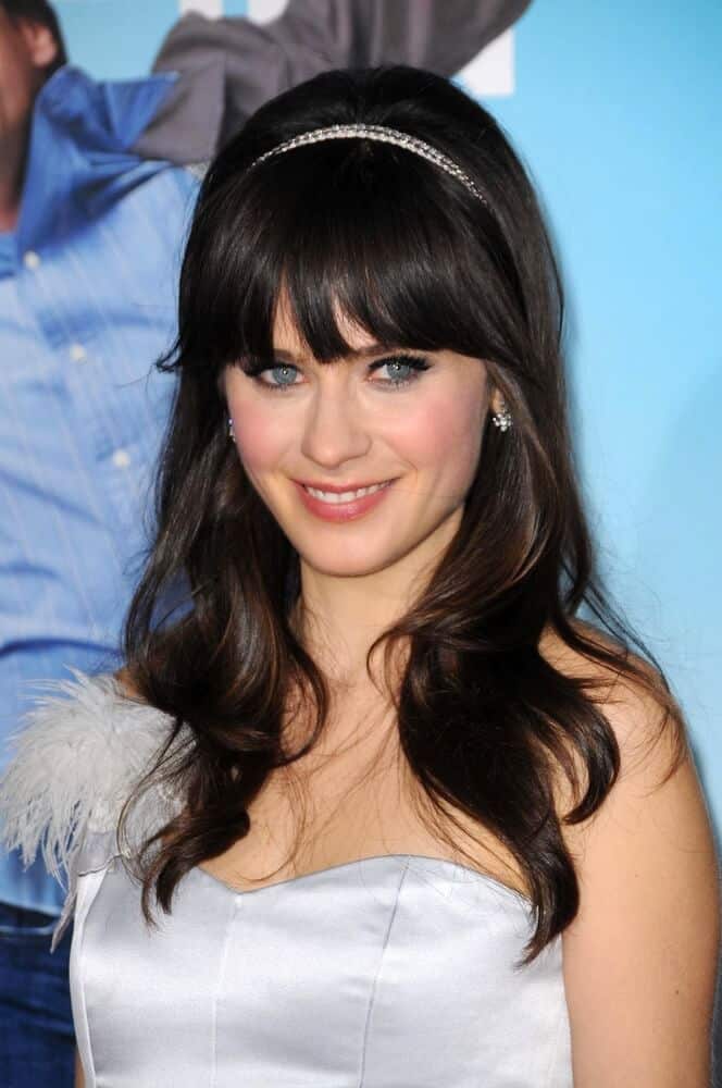 Zooey Deschanel's wavy hair with thick, blunt bangs embellished with a pearl headband.