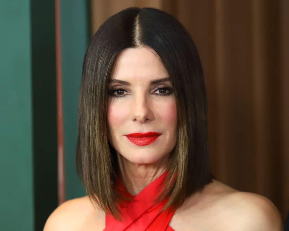 Straightforward and trouble-free, this hairstyle for women with short straight hair is sported by the legendary Sandra Bullock. Notice how a slightly tilted lob coupled with soft caramel highlights in ultra sleek deep brown hair make her look effortlessly stylish. 