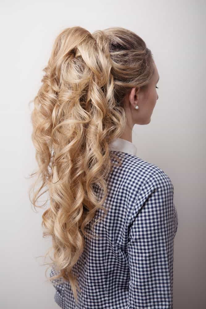 Featuring long, curly blonde hair with lowlights tied in a high ponytail – this hairstyle is truly a classic. While the curls add texture to the hair, the lowlights take the entire look to the next level. 