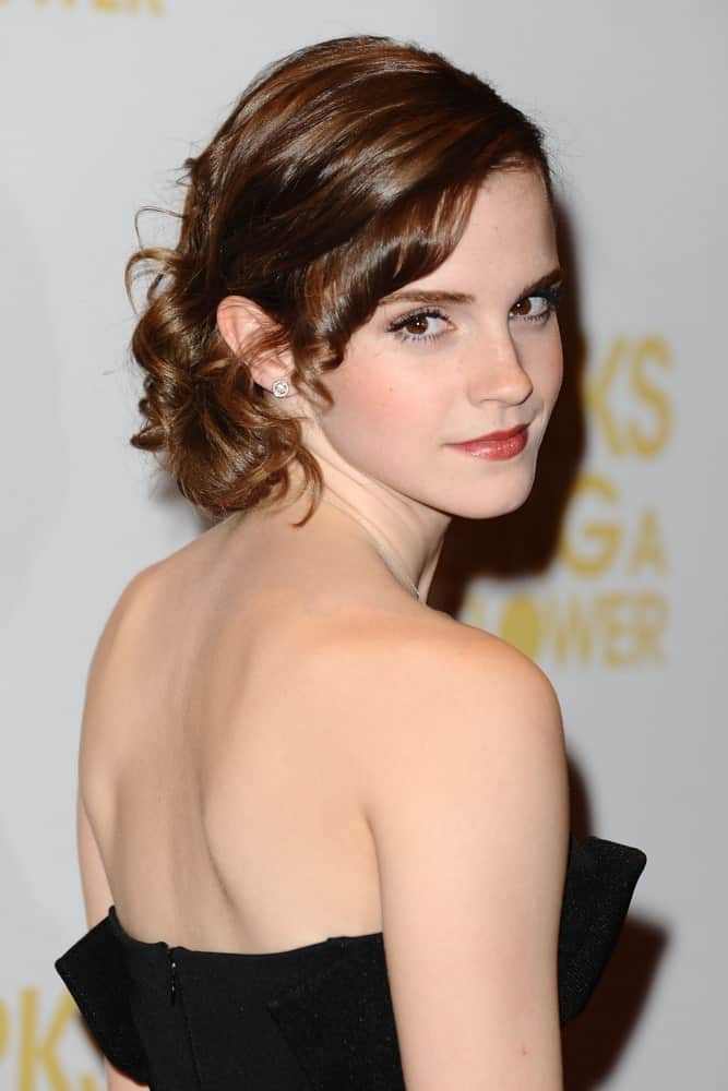 Emma Watson looks like a dream come true in her beautiful short hairstyle. All her hair has been pinned towards the back except from one side where knotted ringlets of small strands of hair have been let loose near the forehead. 