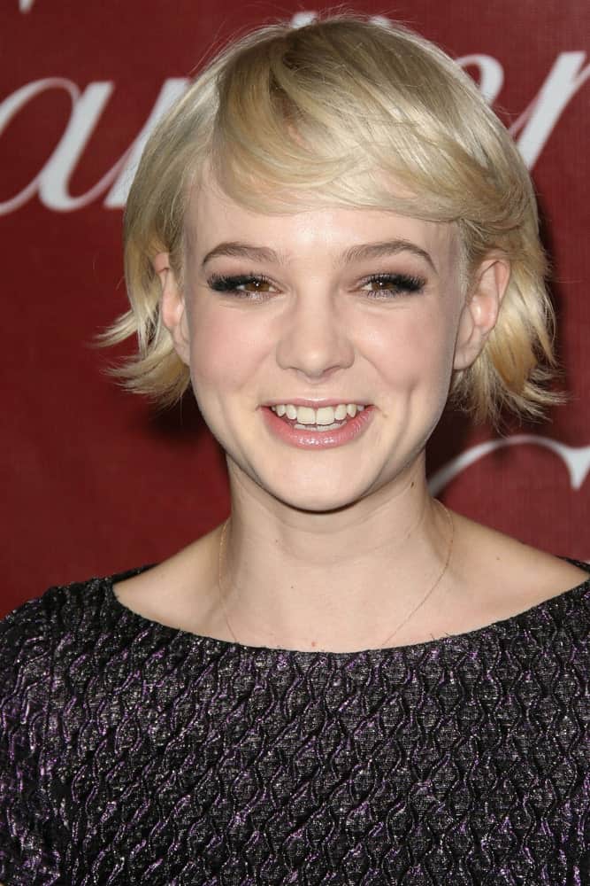 This minimalistic layered bob is worn by the stunning Carey Mulligan where her hair has been cut into feathery strands at ear-level.A similar approach to finishing the short baby bangs together give her a youthful and playful look. 