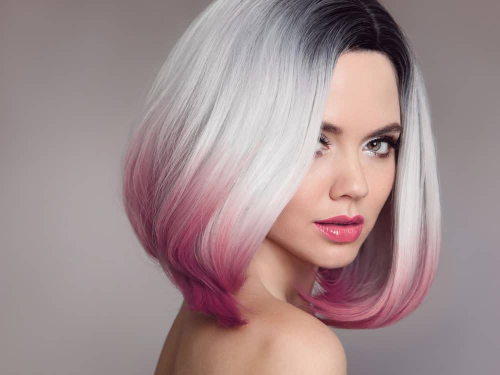 For all those who love to experiment with their hair and have a knack for going big and bold, this is the perfect look for you. This style of highlights has been divided into three sections where the top section has jet black hair, followed by ashy silver-white hair, and then finally, hues of soft pink throughout the bottom. The short bob makes it look even more stylish and funky!