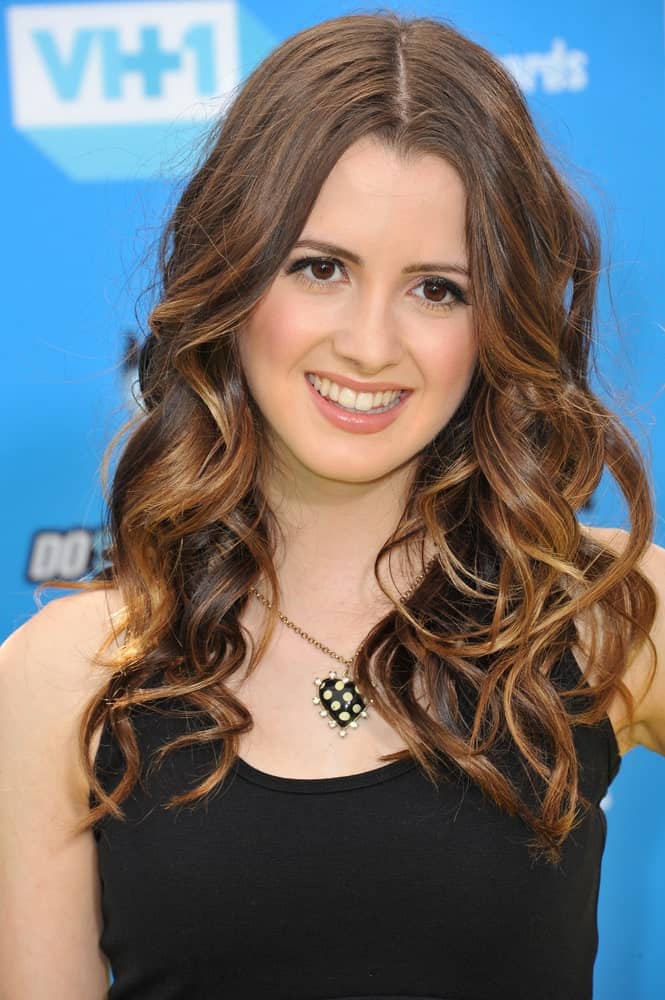 Laura Marano’s hairstyle for women with curly hair might not be something very new but what makes it super chic is the addition of light honey-golden and caramel highlights that shine out on the chestnut brown base. 