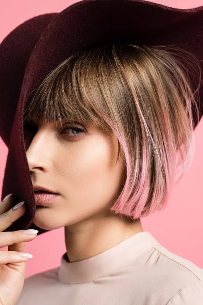 If you love funky looks and styles, you ought to get these highlights done. This is a super short, sleek bob with light golden-brown highlights at the top followed by shades of pink at the bottom.