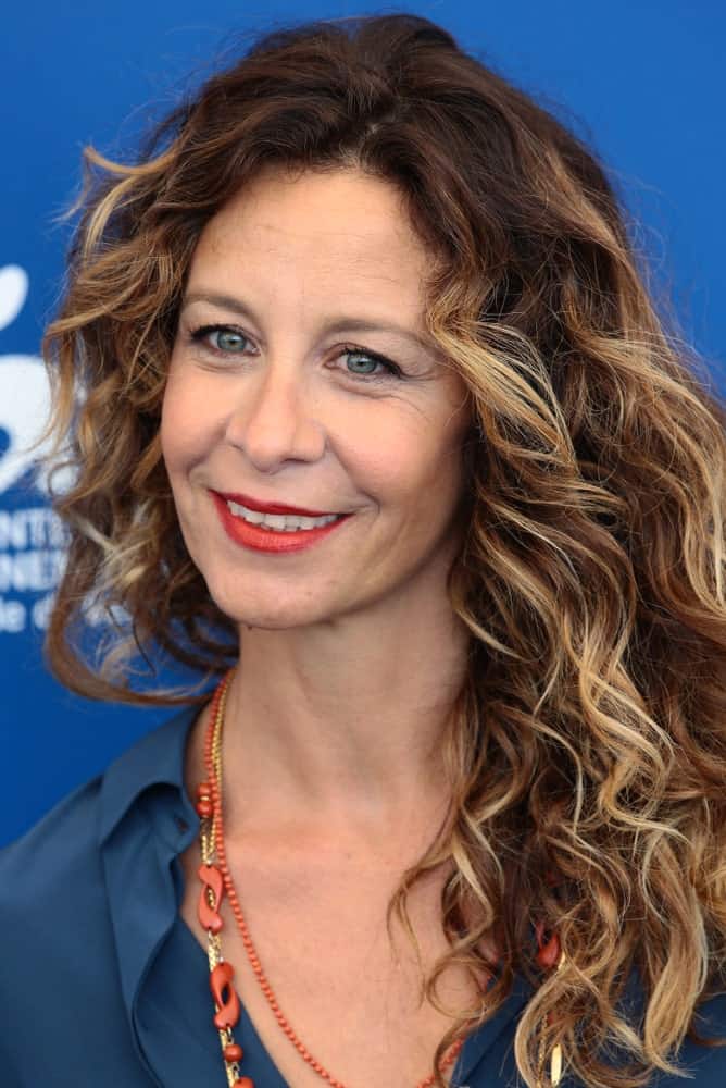 Carlotta Natoli proves that curly hair makes women look gorgeous no matter what their age might be. Gracing her hair with ash gold streaks against the Havana brown shade further cuts down on her years, making her look fashionable.