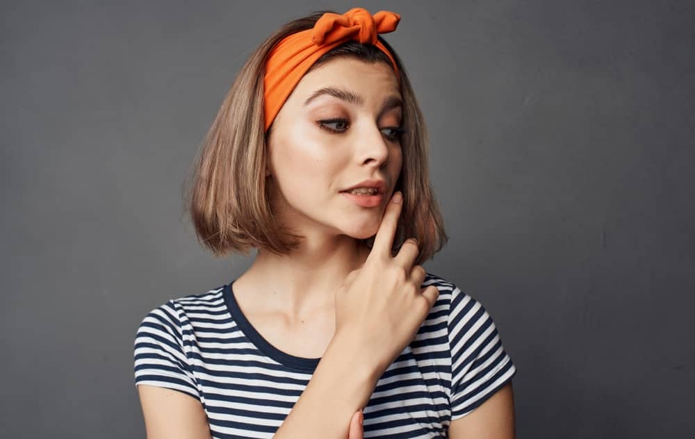 Don’t underestimate the importance of accessories when it comes to your hair. Add a brightly colored headband on top of your short bob; the wider the better. The thick band will keep your hair from getting into your eyes and will let the hair on your side frame your face perfectly.