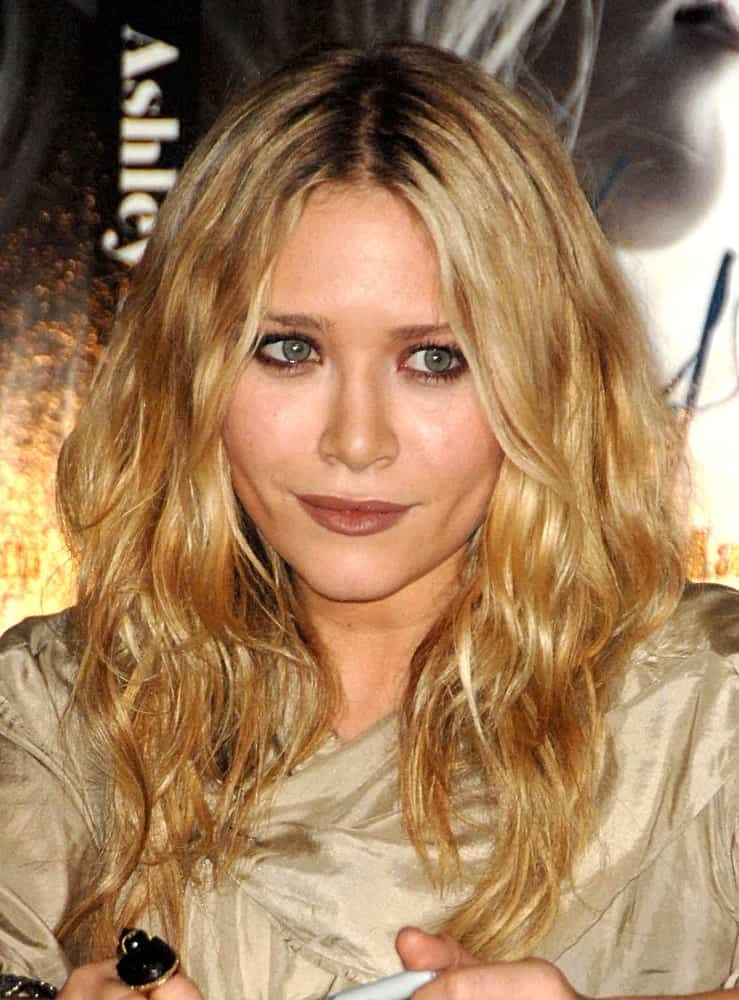 vThe golden hair helps accentuate the messy tousled hairstyle. They create a really nice look since the soft waves in the hair frame the face perfectly. 