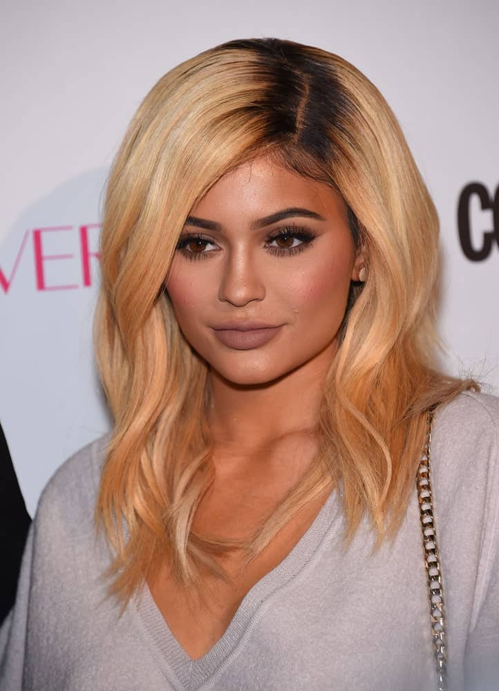 Want to look like the world’s youngest billionaire? Try going for dark roots and a contrasting, lighter shade for the rest of your hair. Kylie Jenner’s waves look so classy here; we absolutely wish we could steal the look! 