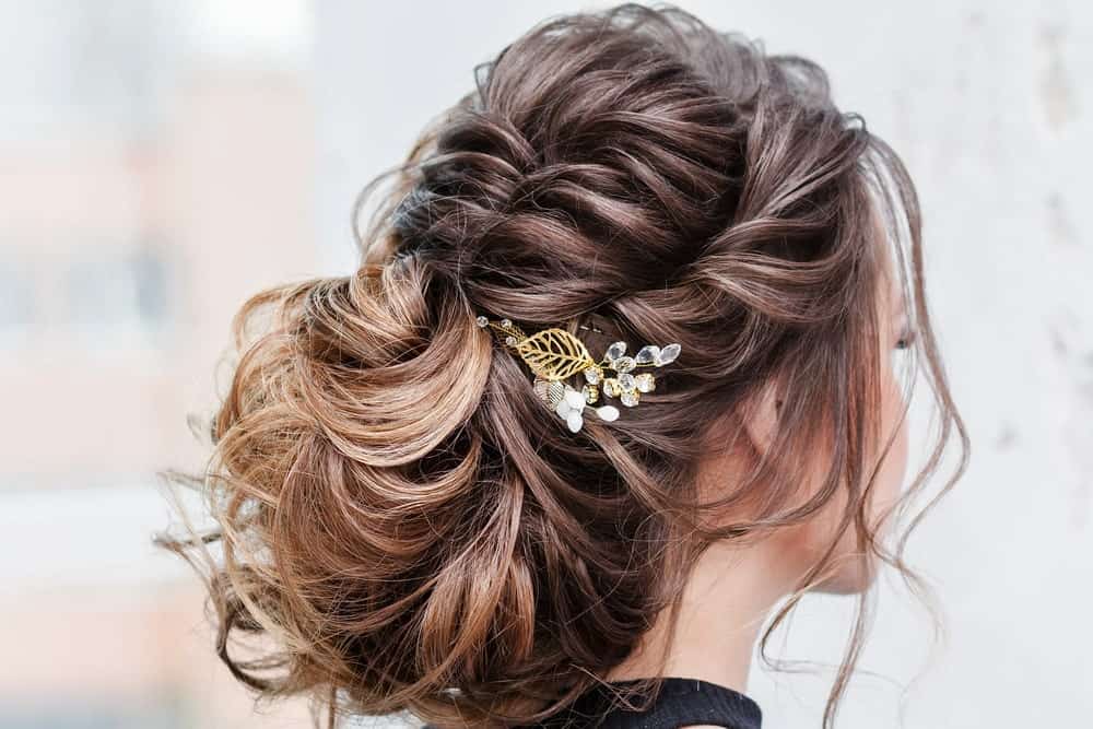 This is one of those “messy” looks that are impossible not to like. The balayage brings out the best of the brunette hair as it is styled at the back in a rather fancy bun. In the front, the hair is twirled towards the back and adds to the bun while a few loose strands complete the look by perfectly framing the face. 