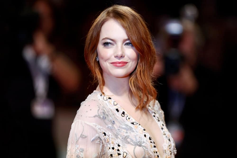 Although Emma Stone is a natural blonde, the actress is more often seen with her hair a brilliant shade of Auburn. In fact, many people don’t even know red is not Stone’s natural hair color. However, with her inspiring fashion sense, Stone now owns the color. Here, the actress is sporting side-parted loose asymmetrical waves with the rest of her hair pulled back in a bun. The look is both chic and modern.