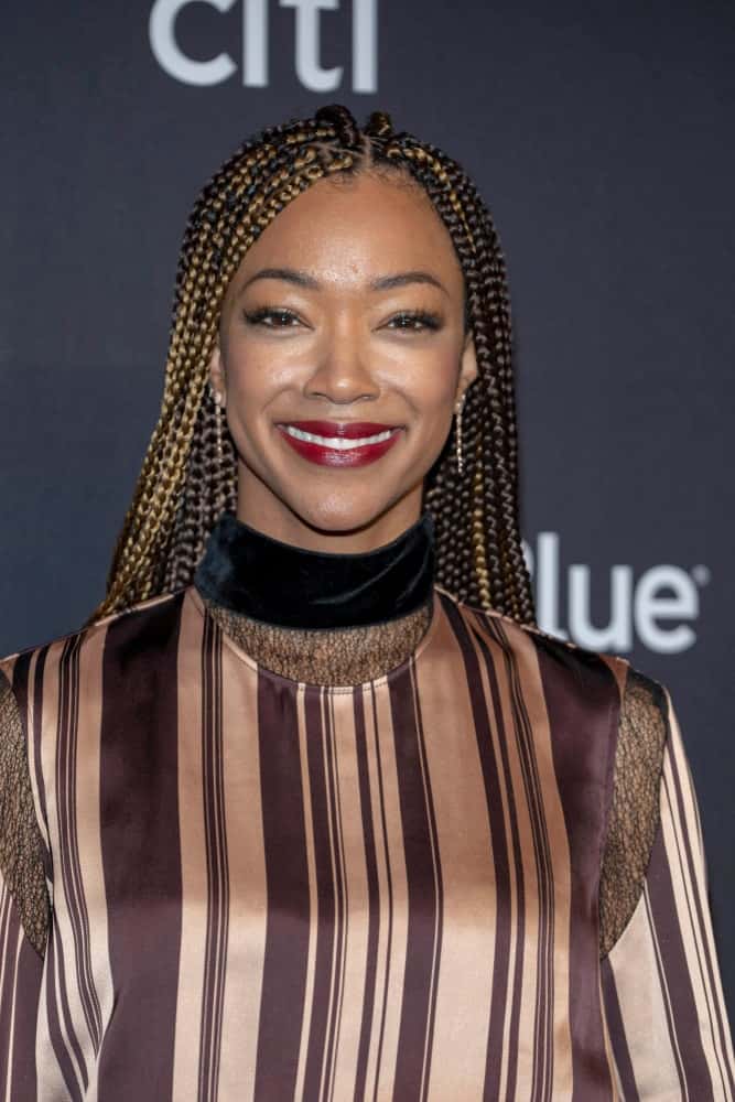 Another beautiful celebrity, Sonequa Martin-Green, was seen rocking Fulani braids at the 2019 Paley Fest. The actress styled her Fulani braids in a minimalistic way. Half her locks remained dark brown while the other half was colored a beautiful burnished gold. The “Star Trek: Discovery” actress chose to forego the traditional shells, beads, and thread decorations in her cascading hair, preferring to show off the beautifully two-toned dangling length of her hair.