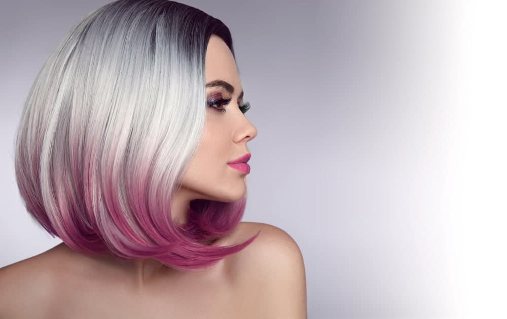 Silver hair color is all the rage these days. Pair it up with another rocking hair color, like purple, and you will turn heads wherever you go. Here, this model has dip-dyed her silver-toned hair with a matte magenta color and styled it into a very stylish shoulder-skimming bob.