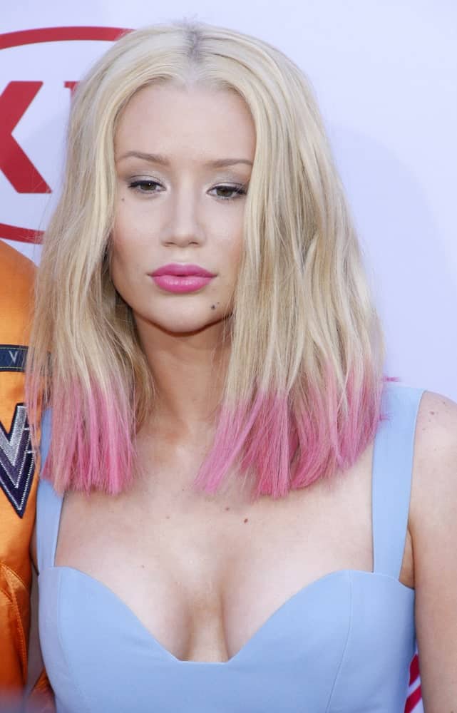 Iggy Azalea has experimented with a lot of hairstyles and this particular multi-colored hairstyle is one of her best looks. The rapper kept the top of her naturally blonde but dip-dyed the ends with a millennium pink color. Not only does the style brighten up her face but it also makes her look younger. Shocking Pink and Red Style