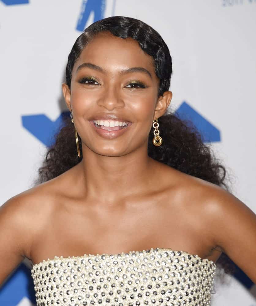 American actress, model and activist, Yara Shahidi, has always topped the afro game. Here we see her flouncing her dense and thick naturally curly hair in a frizzed and volumized ponytail at the back. The hair at the front have been further crimped to take the style to a whole new level. 