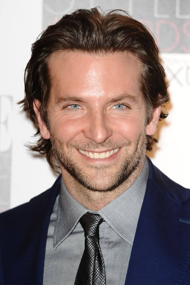 Even though he is a phenomenal actor, one of Bradley Cooper’s biggest claims-to-fame is his thick brown voluminous waves of hair. The “A Star is Born” actor is one of the few Hollywood actors who sports shoulder-length hair and rocks it. On red carpet events, Cooper often styles his hair in a wet look by adding styling product to his wavy locks and pushing them back away from his forehead. The style further highlights the actor’s prominent cheekbones and piercing eyes.