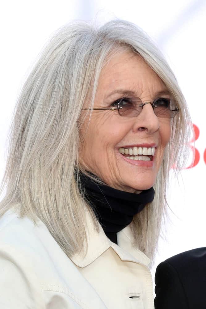 Captured less than a year ago, this picture shows that Diane Keaton is true to her words. She doesn’t perceive hair turning gray to be a very big deal and thus, didn’t once consider hiding them with darker dyes. She prefers to wear her now completely grayed hair in a shoulder-length cut coupled with a few layers to look exquisite beyond words.