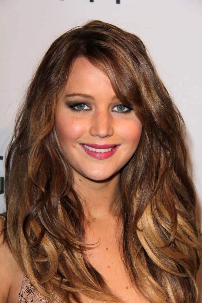 At the 85th Academy Awards held in Beverly Hills, CA, the Oscar-winner Jennifer Lawrence was spotted flaunting her thick and healthy, voluminous hair in a simple and loose style. However, she did get some honey blonde and caramel lowlights in her chestnut brown hair to accentuate the down-style and make it more captivating.
