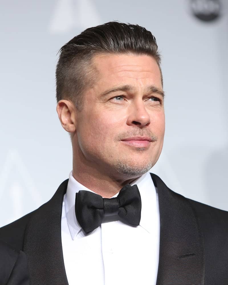 While his military-themed fade haircut for men made it big time, Brad Pitt’s slicked-back fade haircut is relatively less known. The style is not particularly new but is still favored amongst men looking for an uncomplicated and trouble-free haircut that can make them look effortlessly stylish. Slathering some gel and brushing your center hair all the way is also useful if you are growing your hair out after a buzzcut or a minimalistic fade that you might have gotten at some earlier time.