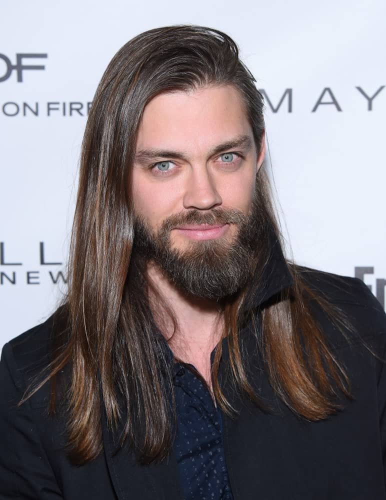 Tom Payne is another great name that you think of when it comes to men with long hair. He pulls off his super long and straight hair with absolute perfection, and it also suits him so well. His hair has been parted from the side that gives it a very voluminous look. The addition of the slightly long beard and mustache looks really classy with this hair making him look truly handsome. 