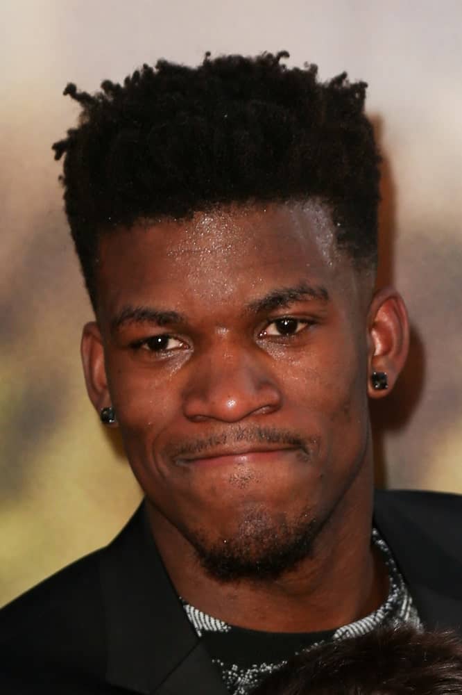 Men with coarse or extra curly hair need not despair because the NBA star, Jimmy Butler, provides a great hack to tackle those unruly locks – go for a fade haircut. Shaving off the edges, the player let the thick and coiled locks nest only above his head to achieve a fairly neat and manageable hairstyle. This fade with twisted locks clicked fellow sportsmen so much that almost half of the basketball league copied Butler’s haircut.  