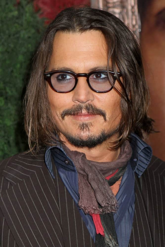Looking for ways to jazz up your boring long hair? Perhaps you can take a leaf out of Johnny Depp’s hair playbook. He has almost shoulder length hair with a middle parting that he has greatly accessorized with black, thick-rimmed tinted glasses. His beard style perfectly complements his long hair, making him look different and cool.
