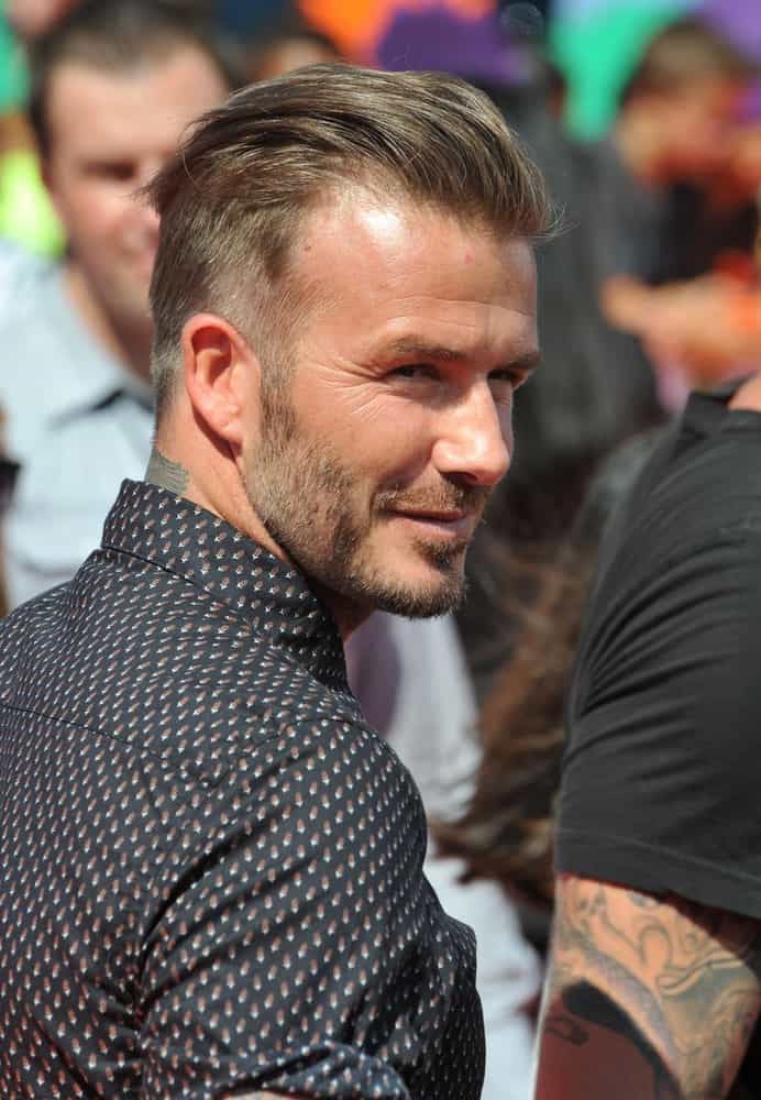 Although this style comes closer to an undercut than a fade haircut, it still deserves a special mention in our list nonetheless because it was not just adored by the skilled footballer/ fashion icon himself (he sported it for years after all) but also loved by his fans worldwide. Beckham styled the longer strands at the top in a slicked-back manner rather than letting them drape over the sides for a more refined and luxe look.