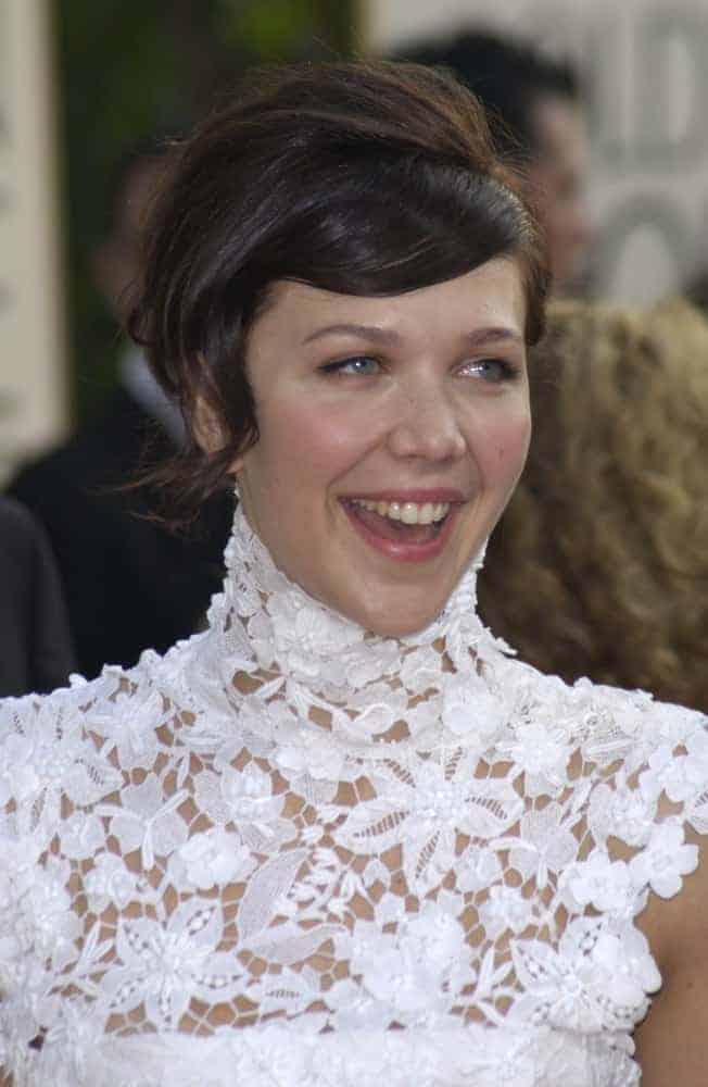 Maggie Gyllenhaal was at the Golden Globe Awards at the Beverly Hills Hilton Hotel on January 19, 2003. She paired her lovely white dress with a short brunette side-swept hairstyle.