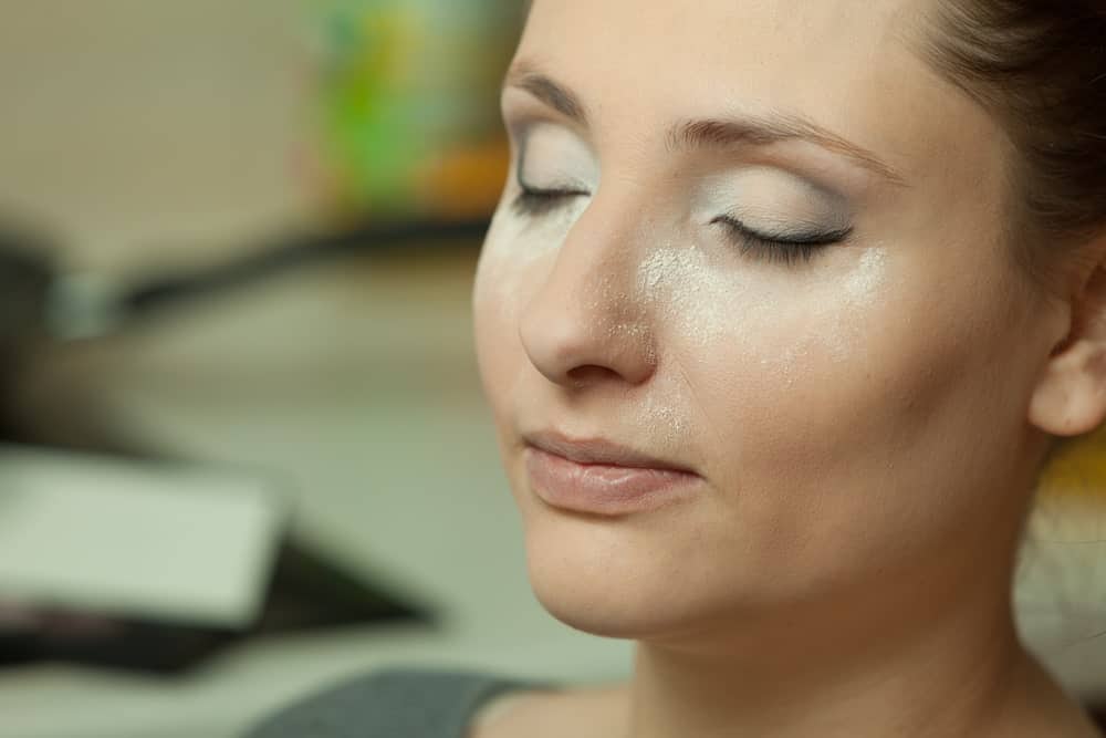 Woman with setting powder on her face.