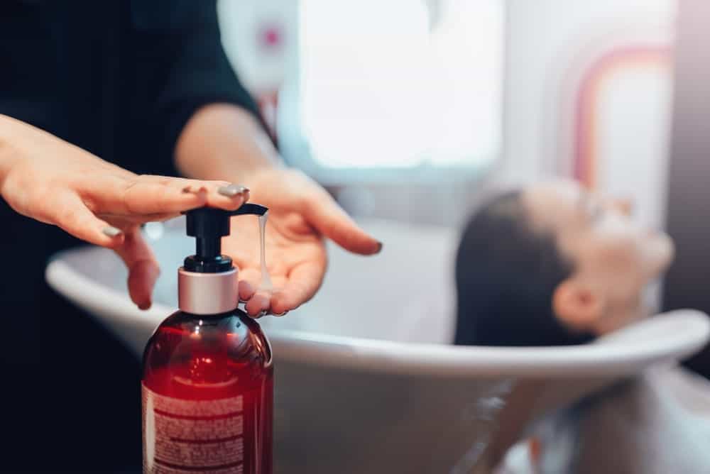 A Hairdresser WaA hairdresser washing customer’s hair with a hair shampooshes Customer’s Hair