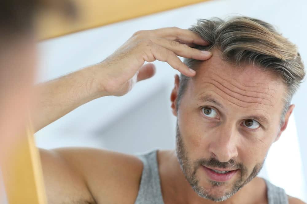 Middle-aged man worrying about his ageing hair.