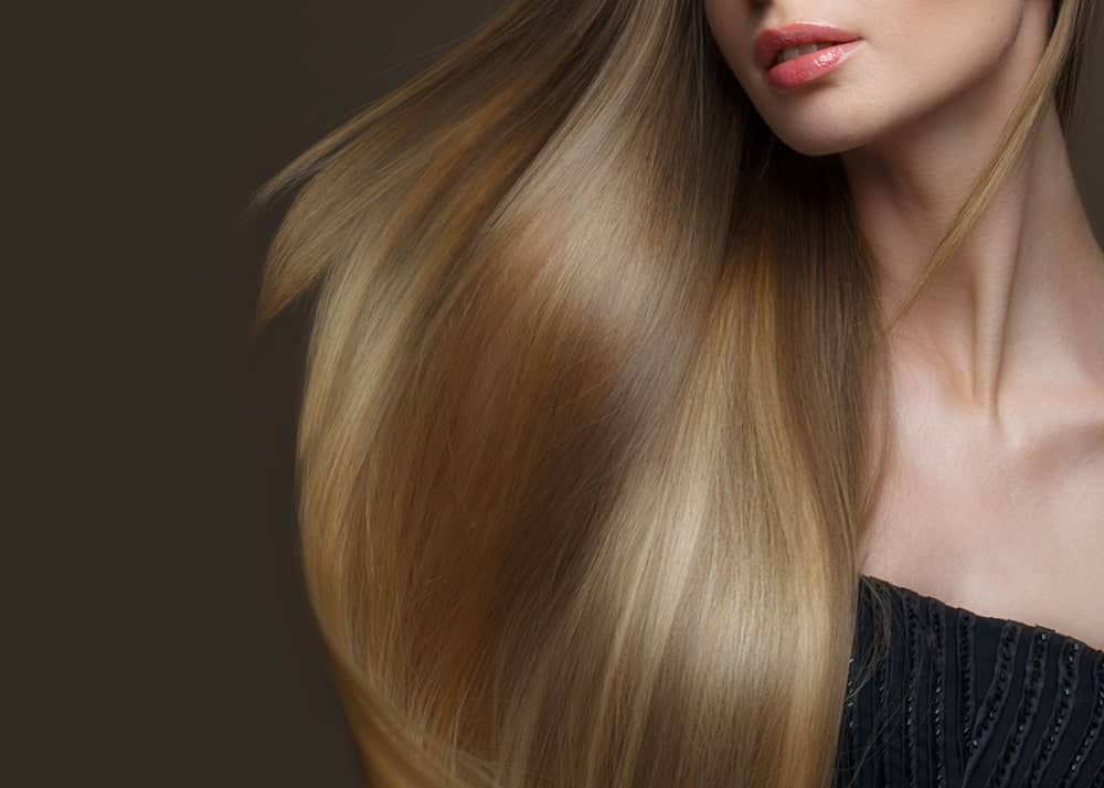 Shot of a woman's lips and soft-looking long brown hair.