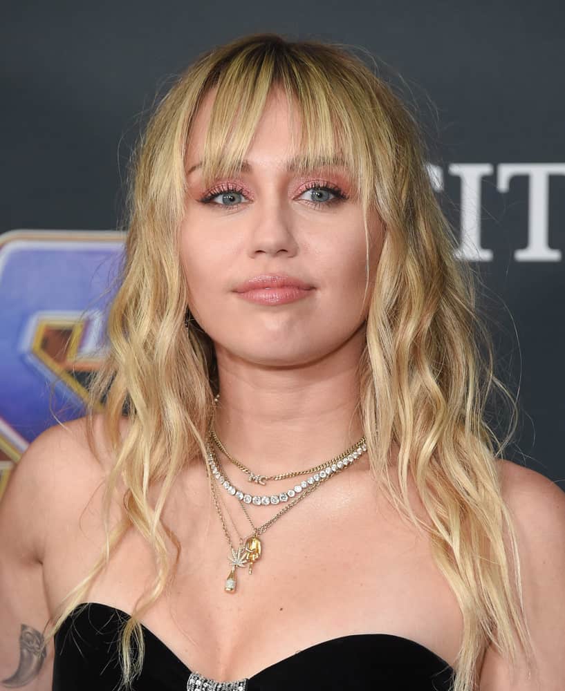 Miley Cyrus with Long wavy blonde hair with bangs
