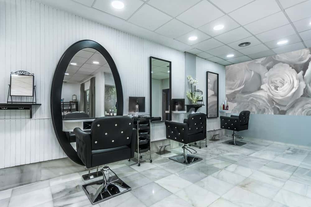 Modern hair salon interior with large wall mirrors and a flower portrait on the side.