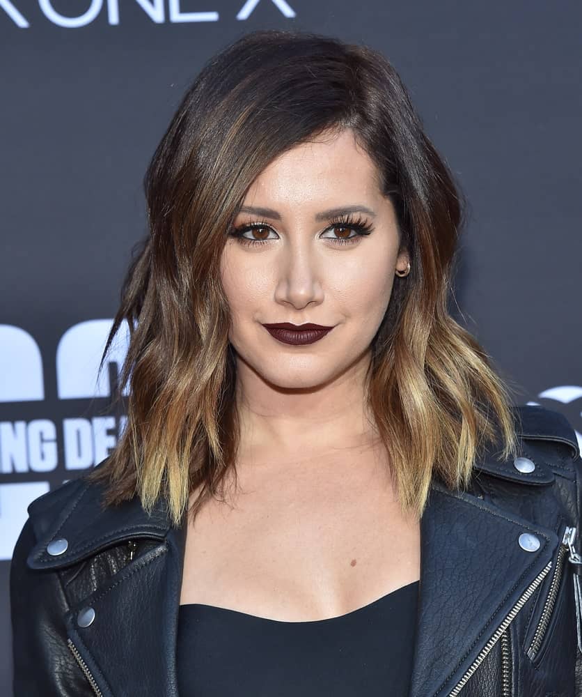 The actress rocks a highlighted beach wave perm on her outgrown hair during the ‘The Walking Dead’ Season 8 Premiere on October 22, 2017. It complements well with her dark lipstick and black getup.