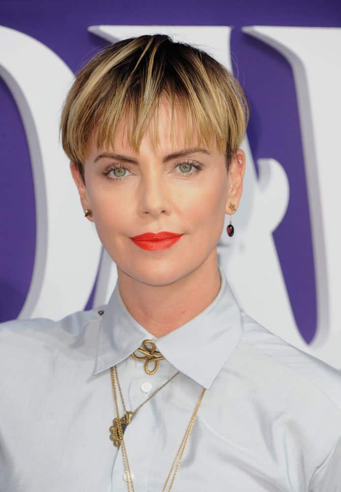 Charlize Theron wore a button-down polo and eye-catching red lipstick at the Los Angeles premiere of ‘The Addams Family’ held on October 6, 2019. She paired it with thin, airy bangs that are highlighted to give it some dimensions.